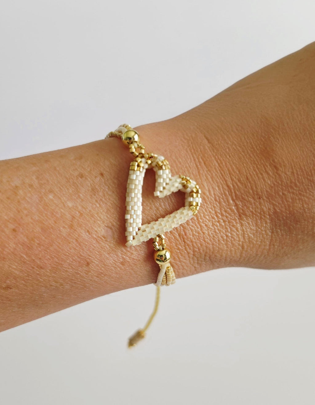 The Love Knot Bracelet in Ivory Pearl, worn on model – handwoven Miyuki jewelry by Franchesca Jewels
